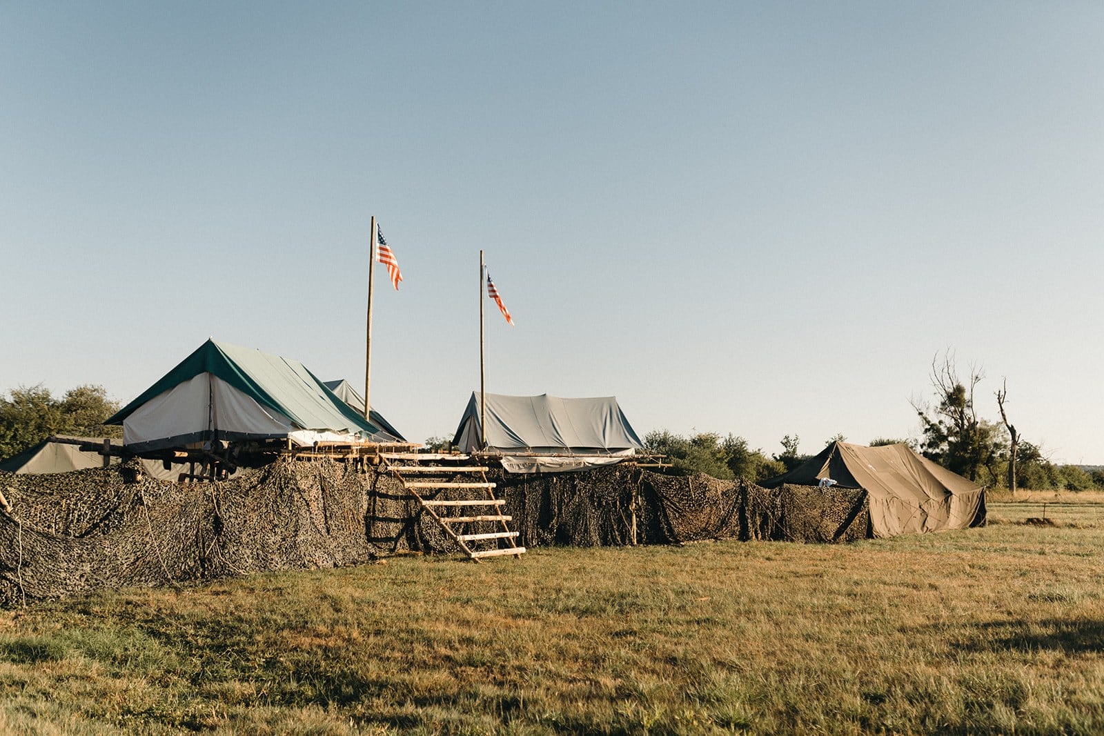 Le camp au coucher du soleil, avec ses tentes, ses drapeaux et ses constructions